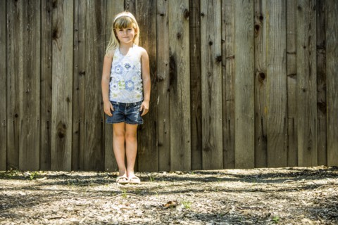 Caucasian girl standing at wooden fence