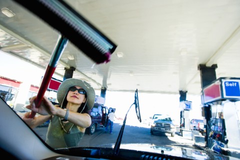 Japanese woman using squeegee on car windshield