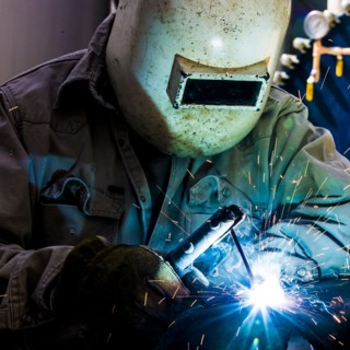 Caucasian welder working in factory