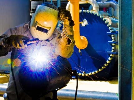 Caucasian welder working in factory