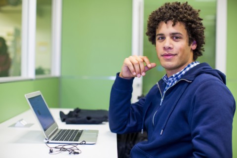 Mixed Race student using laptop in library