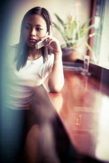 Serious Asian girl talking on cell phone
