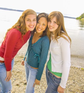 Portrait of smiling girls posing at beach