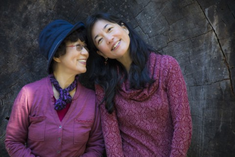 Older Japanese mother and daughter posing at tree slice