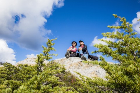 Older Japanese mother and daughter sitting on rock