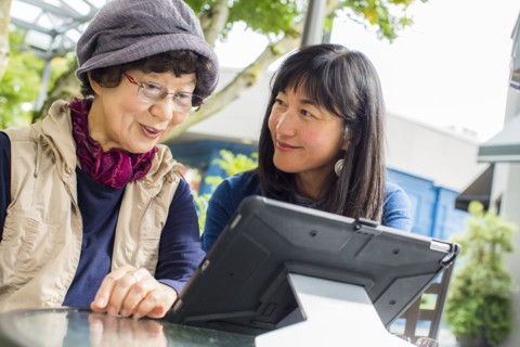 Older Japanese mother and daughter using digital tablet