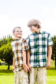 Smiling Caucasian brothers wearing plaid shirts