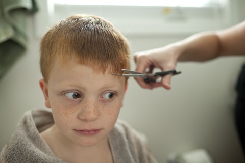 Caucasian mother giving son haircut