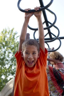 Mixed race boy playing on playground