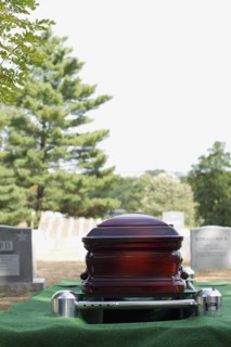Coffin lowering into grave in military cemetery
