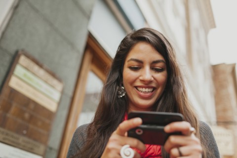 Mixed race woman using cell phone outdoors