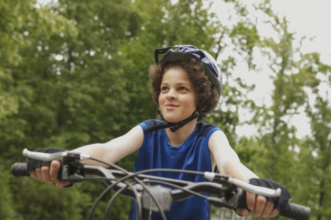 Mixed race boy riding bicycle outdoors