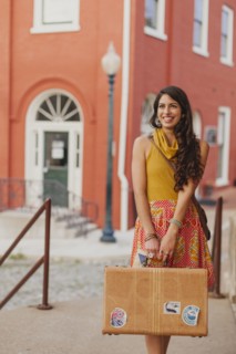 Mixed race woman carrying suitcase on city street