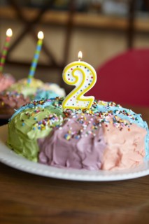 Close up of birthday cake with number two candle