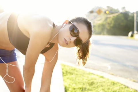 Caucasian runner stretching on sidewalk