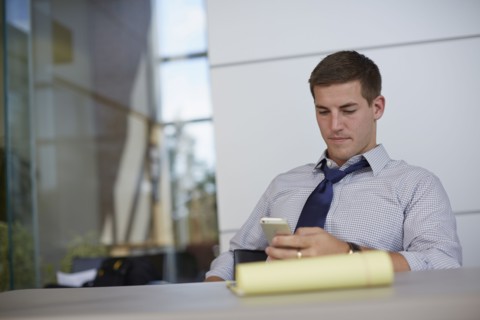 Caucasian businessman using cell phone in office