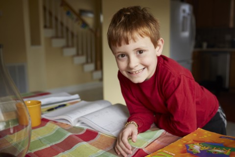 Caucasian boy doing homework at table