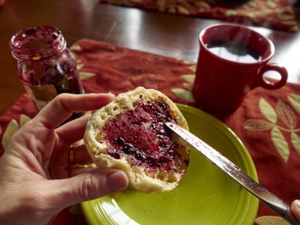 Caucasian boy spreading jam on english muffin
