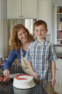Caucasian mother and son decorating cake in kitchen