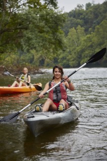 Women paddling kayaks in remote river