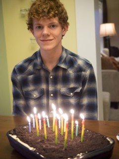 Caucasian boy smiling with birthday cake