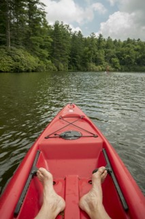 Caucasian teenage boy sitting in canoe on lake