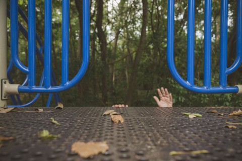 Hands of Hispanic girl reaching on playground