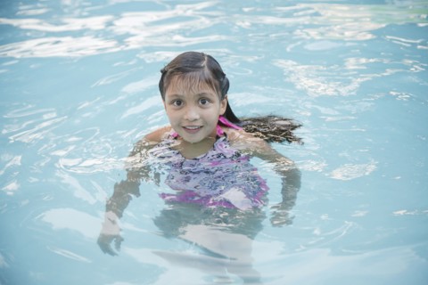 Smiling Hispanic girl in swimming pool