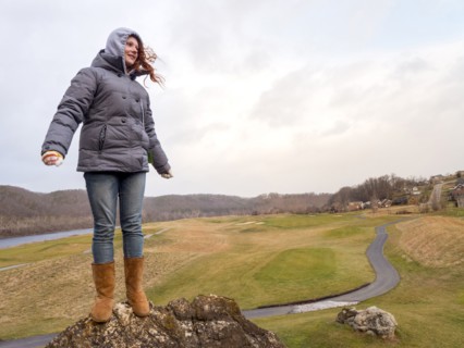 Caucasian girl standing on rock in wind