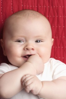 Caucasian baby biting hand