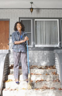 Black woman sweeping front stoop steps