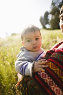 Mother holding baby in field