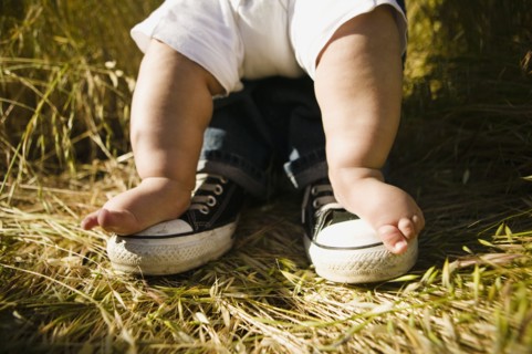 Baby's feet on top of father's feet