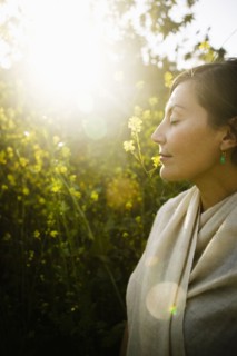 Mixed race woman with eyes closed in field