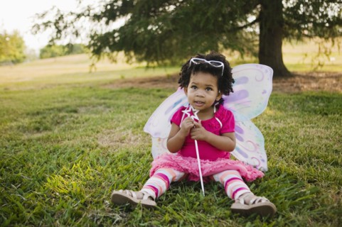 Black baby girl in fairy costume in park