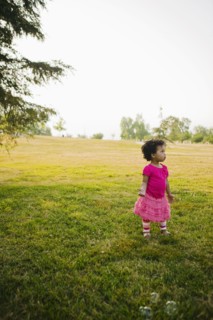 Black baby girl standing in park