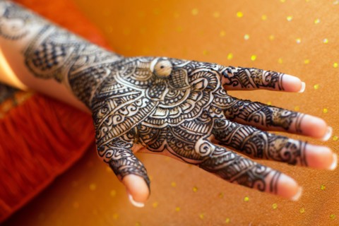 Close up of hand with intricate henna design