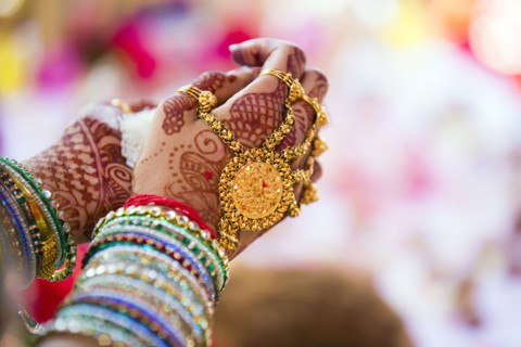 Close up of hands with intricate henna design