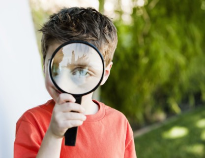 Caucasian boy looking through magnifying glass