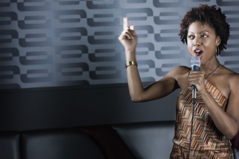 African American woman singing karaoke in nightclub