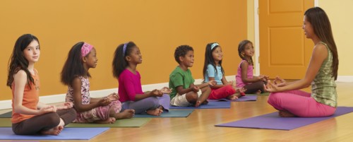 Teacher leading class of children in exercise routine