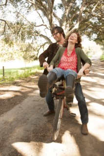 Couple riding bicycle on rural road