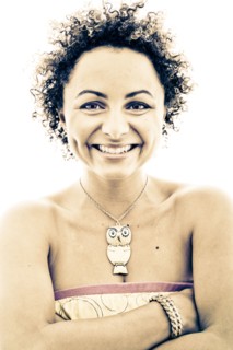 Close up portrait of smiling woman wearing owl necklace