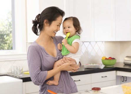 Mother holding baby girl in kitchen