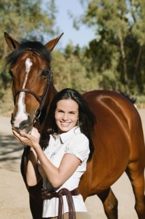 Middle Eastern woman standing with horse