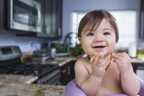 Mixed race baby girl smiling in kitchen