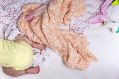 Mixed race baby girl crawling in bed