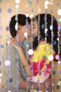 Young couple kissing behind screen