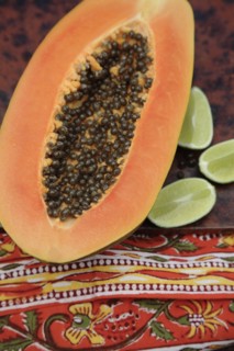 Close up of split papaya and limes