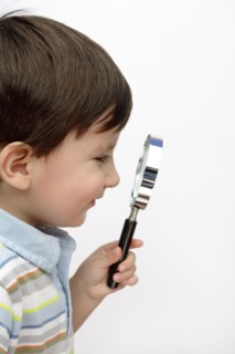Hispanic boy looking through magnifying glass